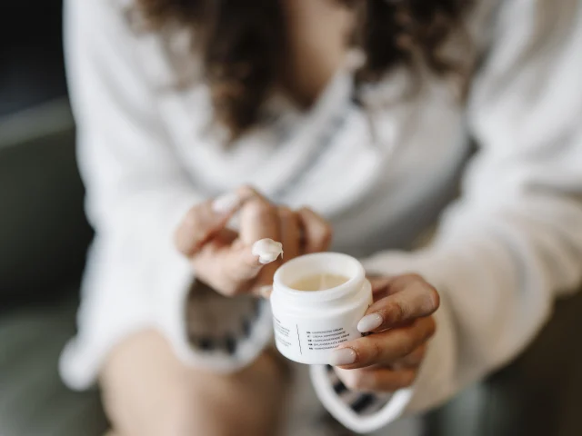 Skincare cream application, representative editorial image