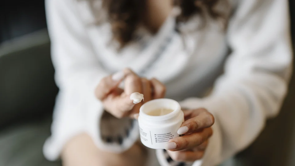 Skincare cream application, representative editorial image