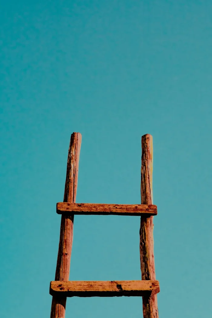 Wooden ladder against a blue wall, representing ladder deals